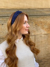 Load image into Gallery viewer, Navy ruffled headband worn over long auburn waves, shown in right-facing profile outdoors.